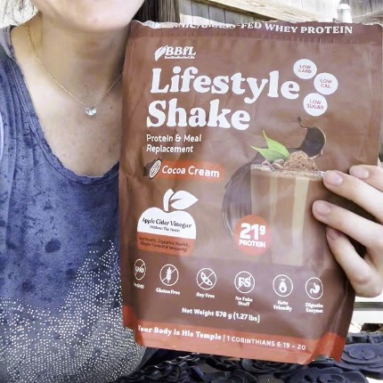 Person holding a BBFL Lifestyle Shake Cocoa Cream bag