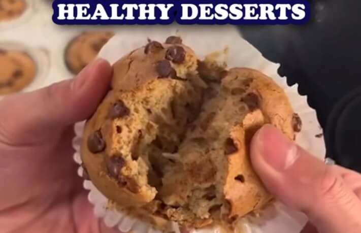 Hands break open a chocolate chip muffin, revealing its fluffy interior, with the text "HEALTHY DESSERTS" above.
